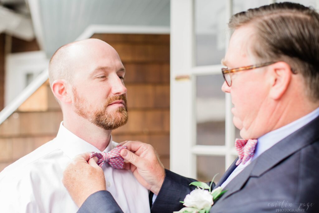 Father of groom tying grooms bowtie