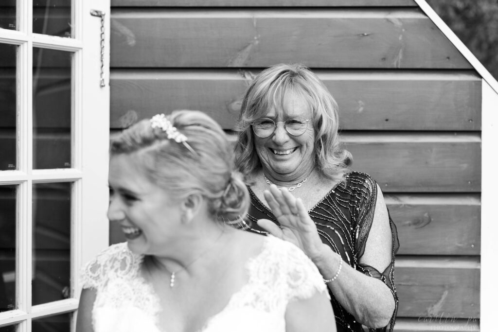 Black and white portrait of mother of the bride smiling at bride
