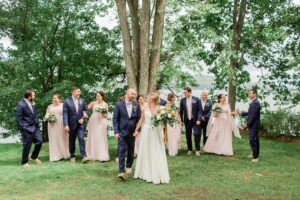 Bridal Party walking together in front of Lake Winnipesaukee at Church Landing