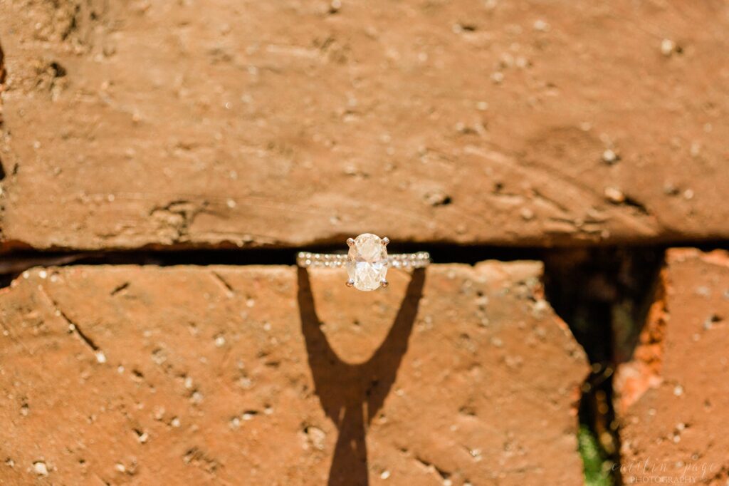 Solitaire engagement ring wedged in between bricks