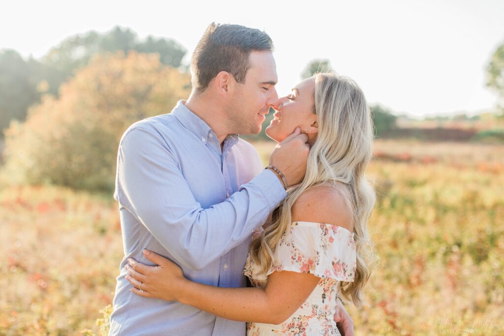 Couple kissing in field at sunset