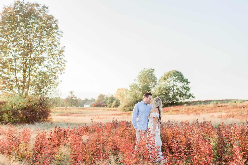 Man and woman standing together in a field at sunset