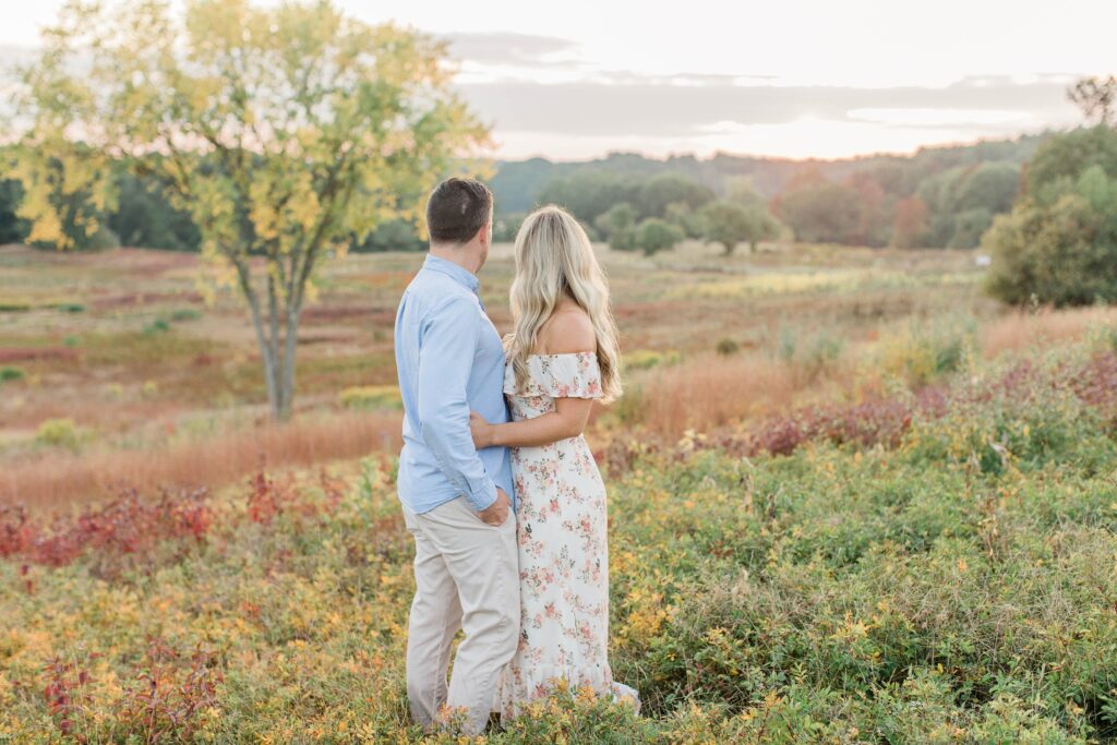 Man and woman standing in a field at sunset at Wagon Hill Farm