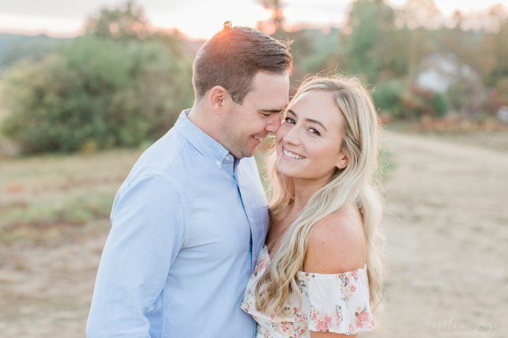 Man nuzzling woman at sunset