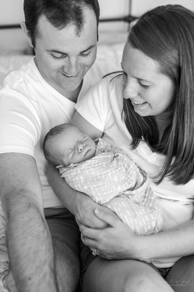 Black and white photo of parents holding newborn baby