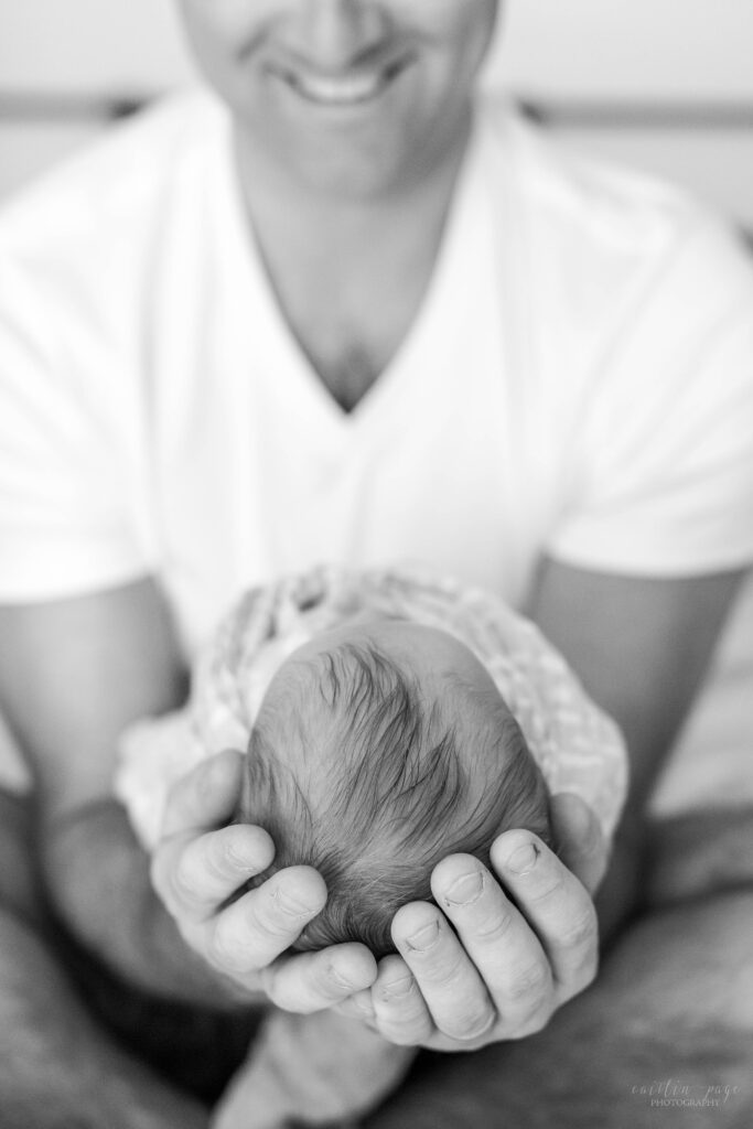 Black and white photo of dad holding baby