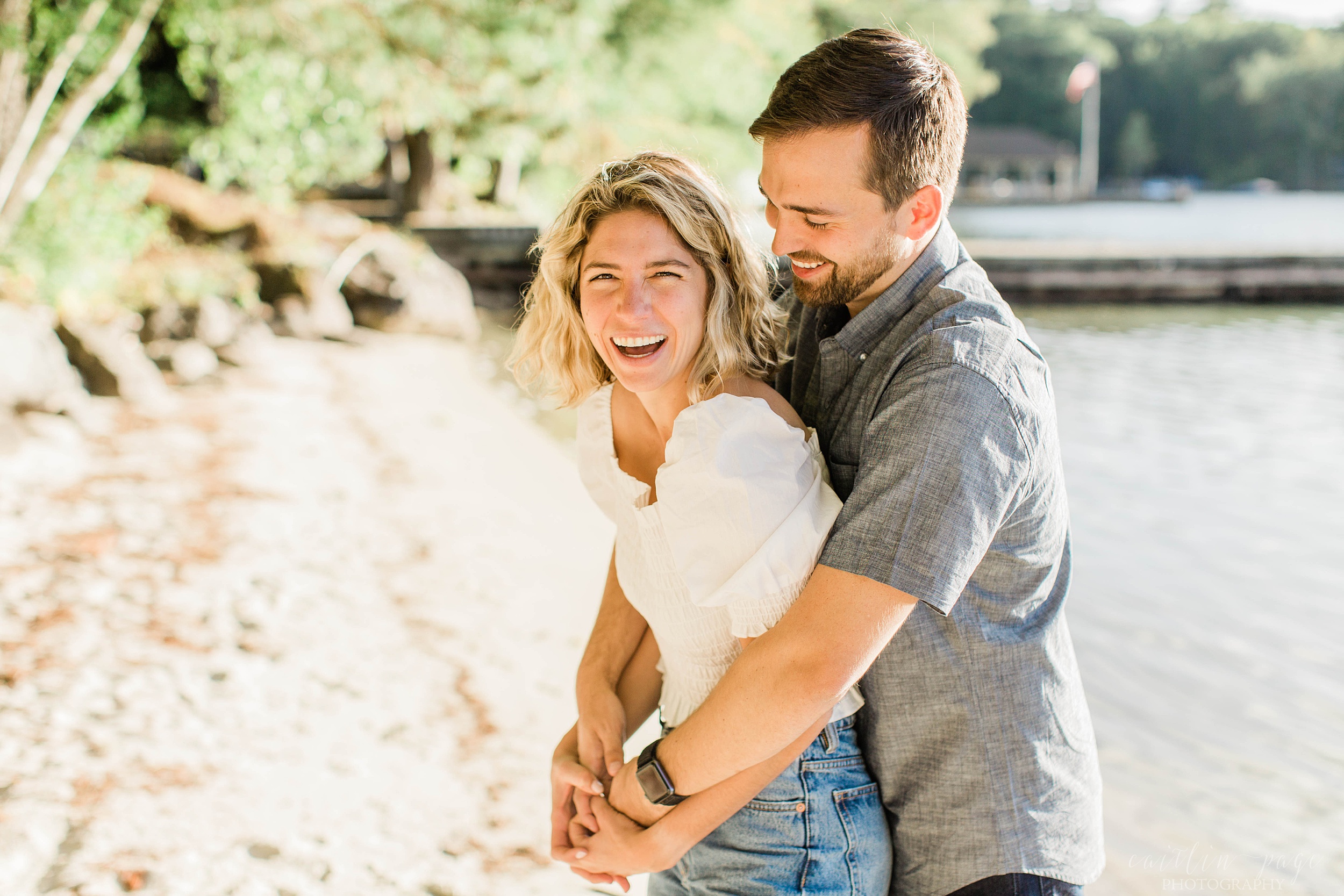 Woman laughing as man holds her around her waist