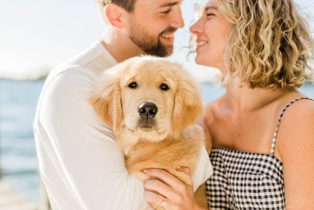 Man and woman holding golden retriever puppy