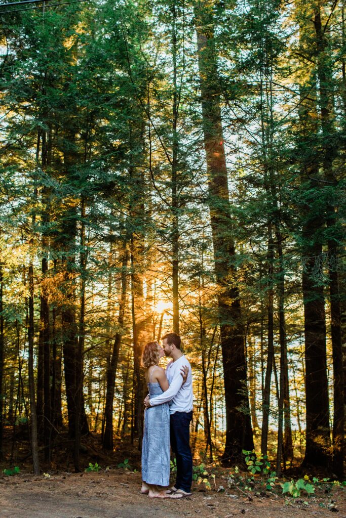 Man and woman standing together in the woods at sunset