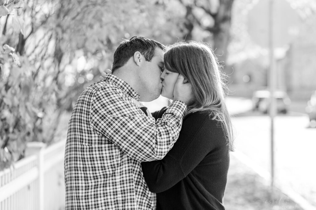 Black and white photo of couple kissing in street