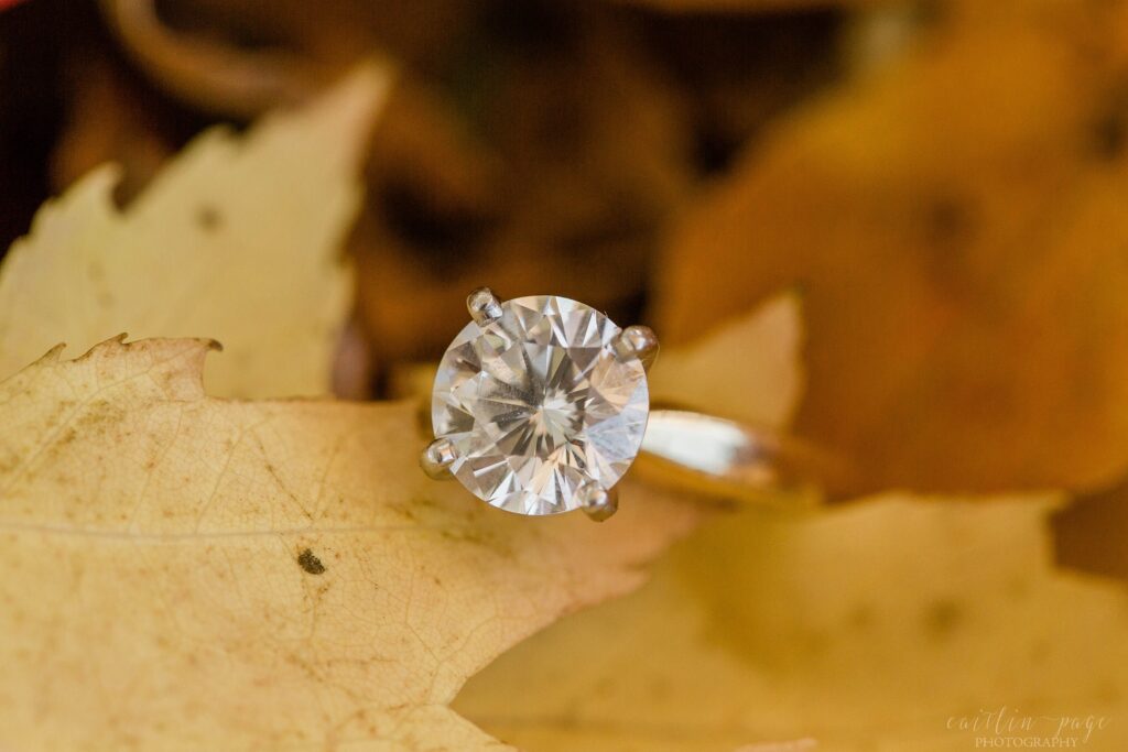 Solitaire diamond engagement ring on yellow leaf