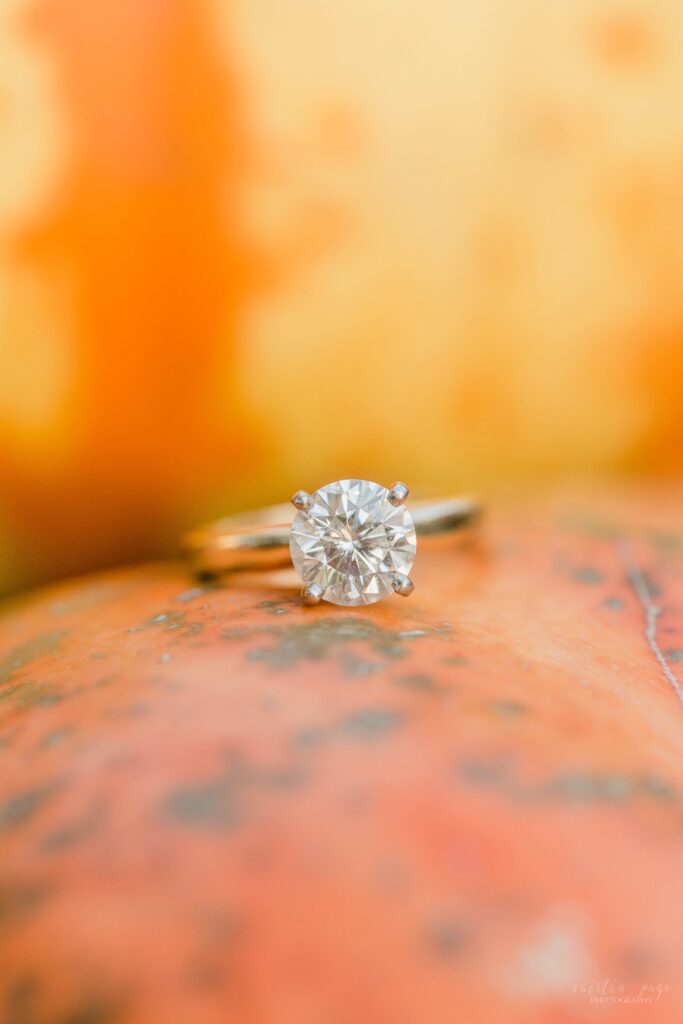 Solitaire engagement ring on top of pumpkin