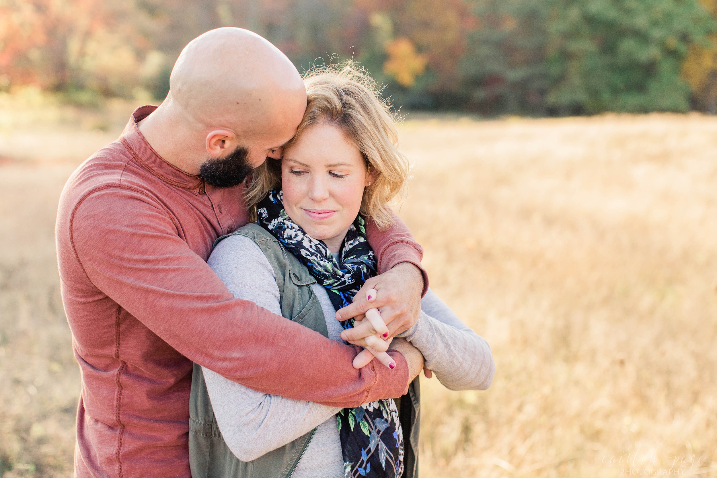 Man and woman snuggled together in a field