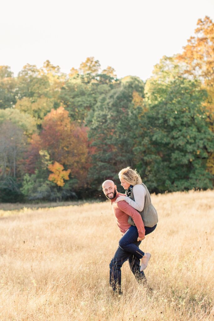 Man carrying woman on his back in a field