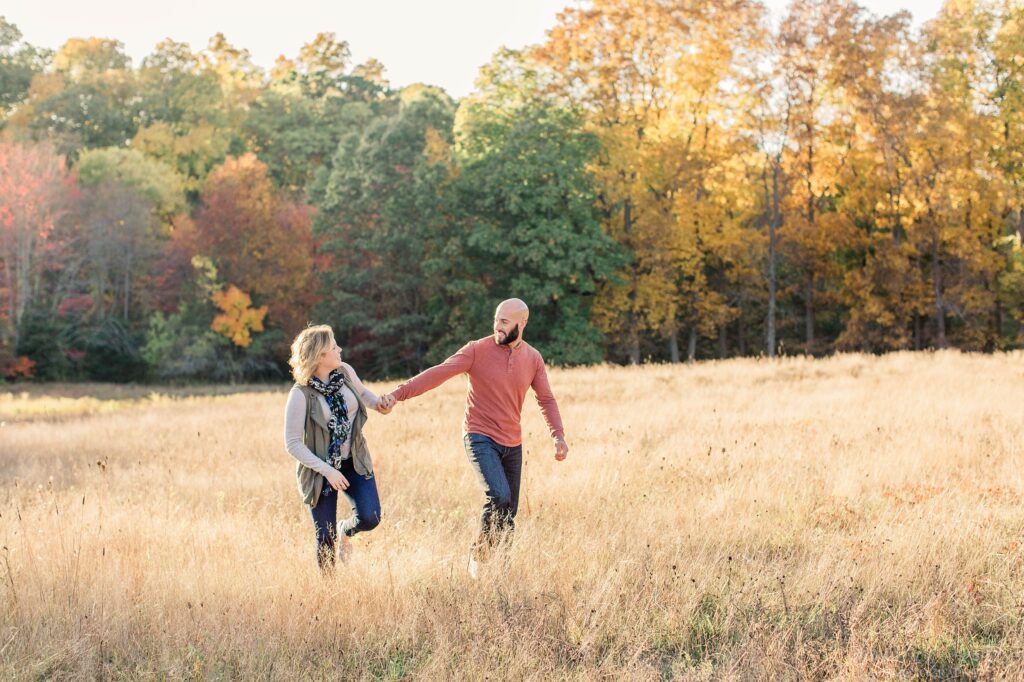 Couple walking through a field together holding hands