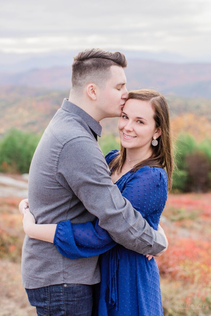 Couple snuggled together on top of mountain