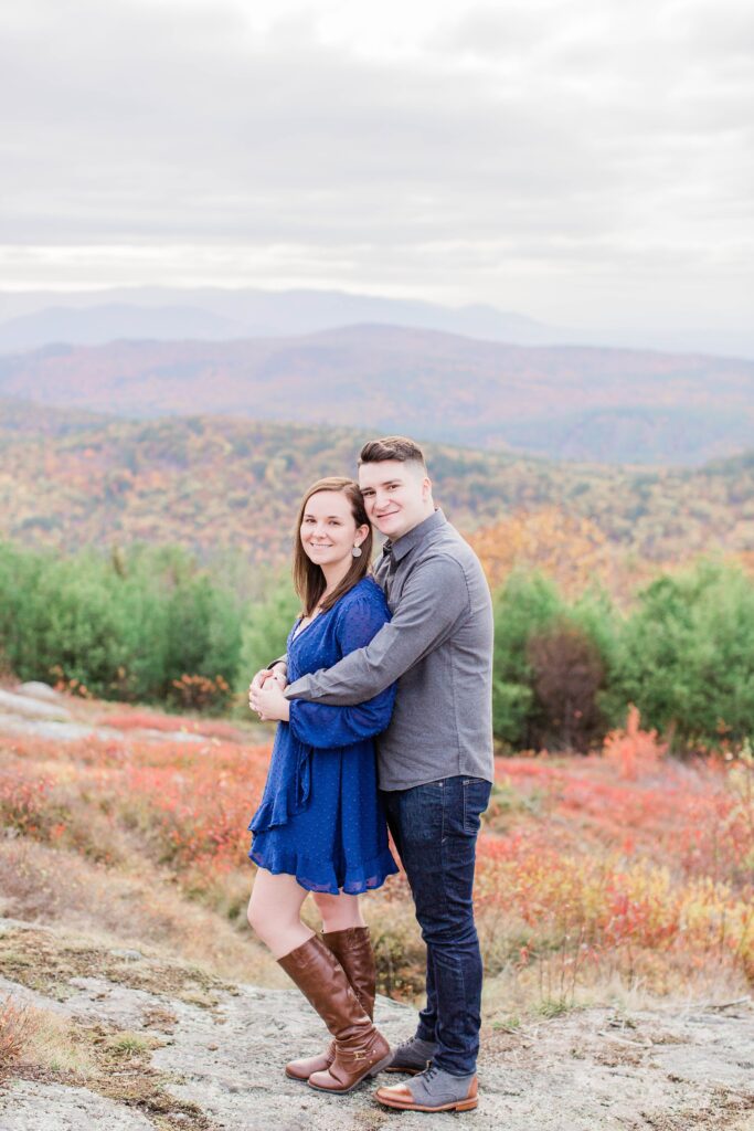 Couple snuggled together on top of mountain