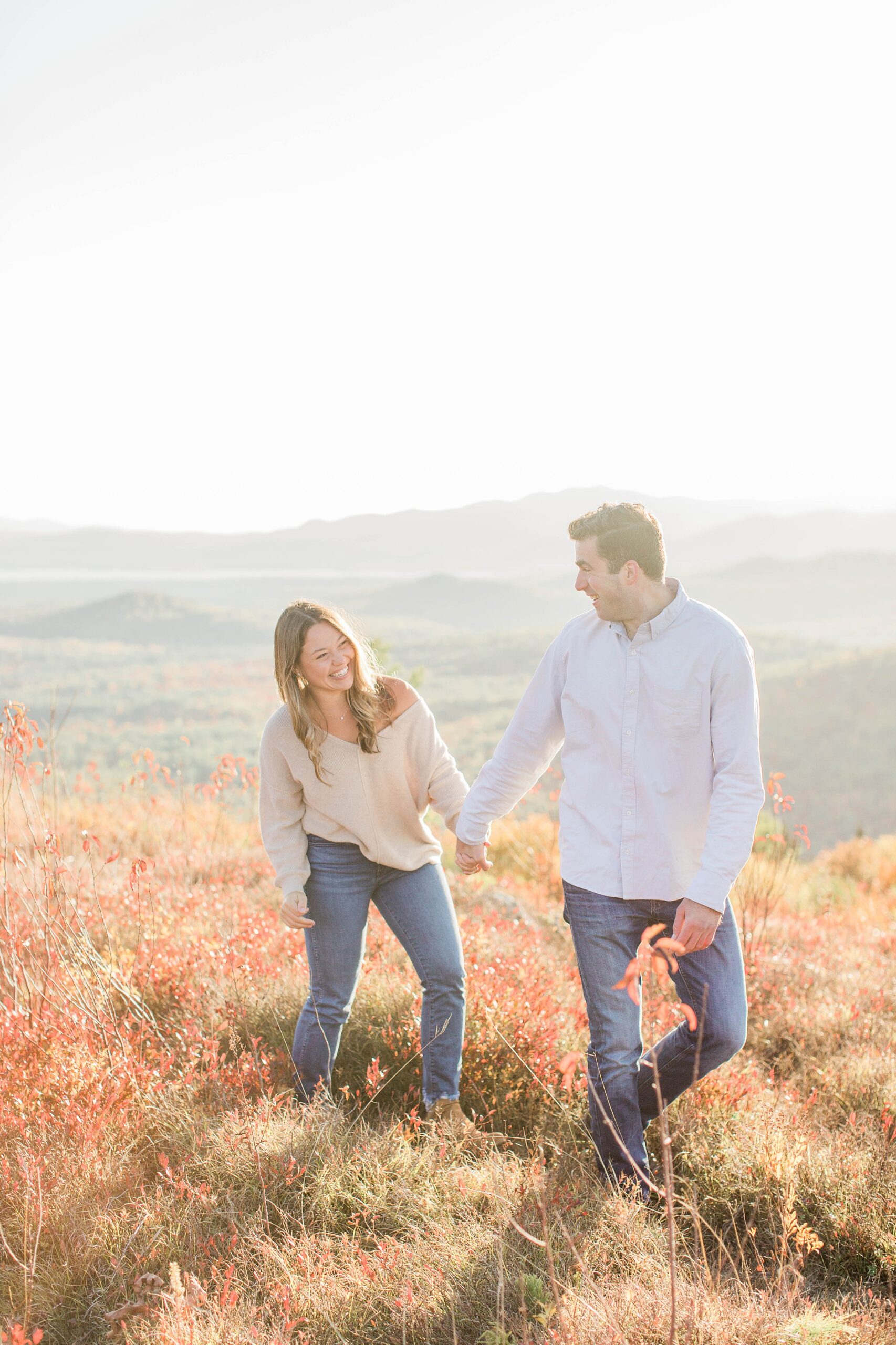 Man and woman walking together on top of mountain at sunset