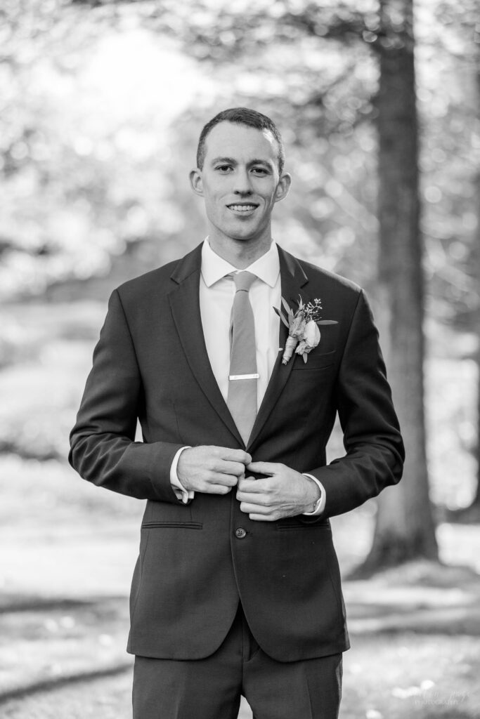 Black and white portrait of groom standing