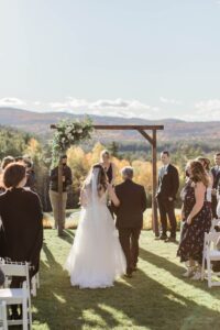 Bride and her father standing at the end of wedding aisle