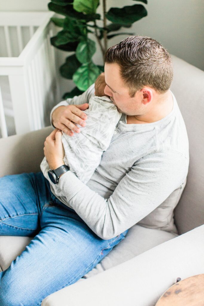 Dad holding baby boy in nursery