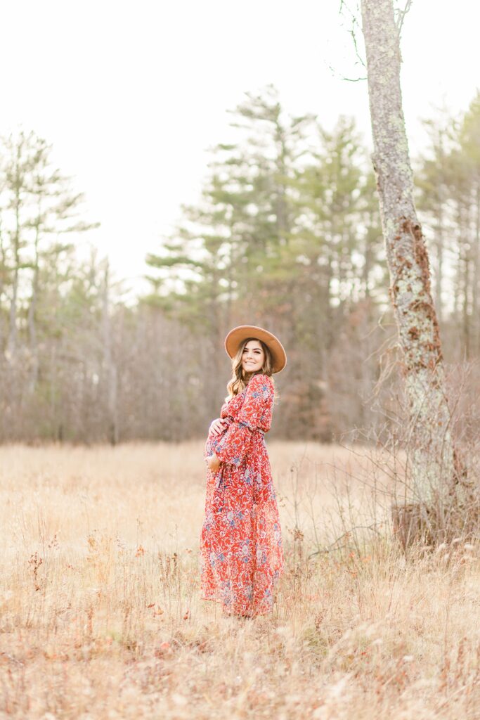 Pregnant woman in a hat standing in a field