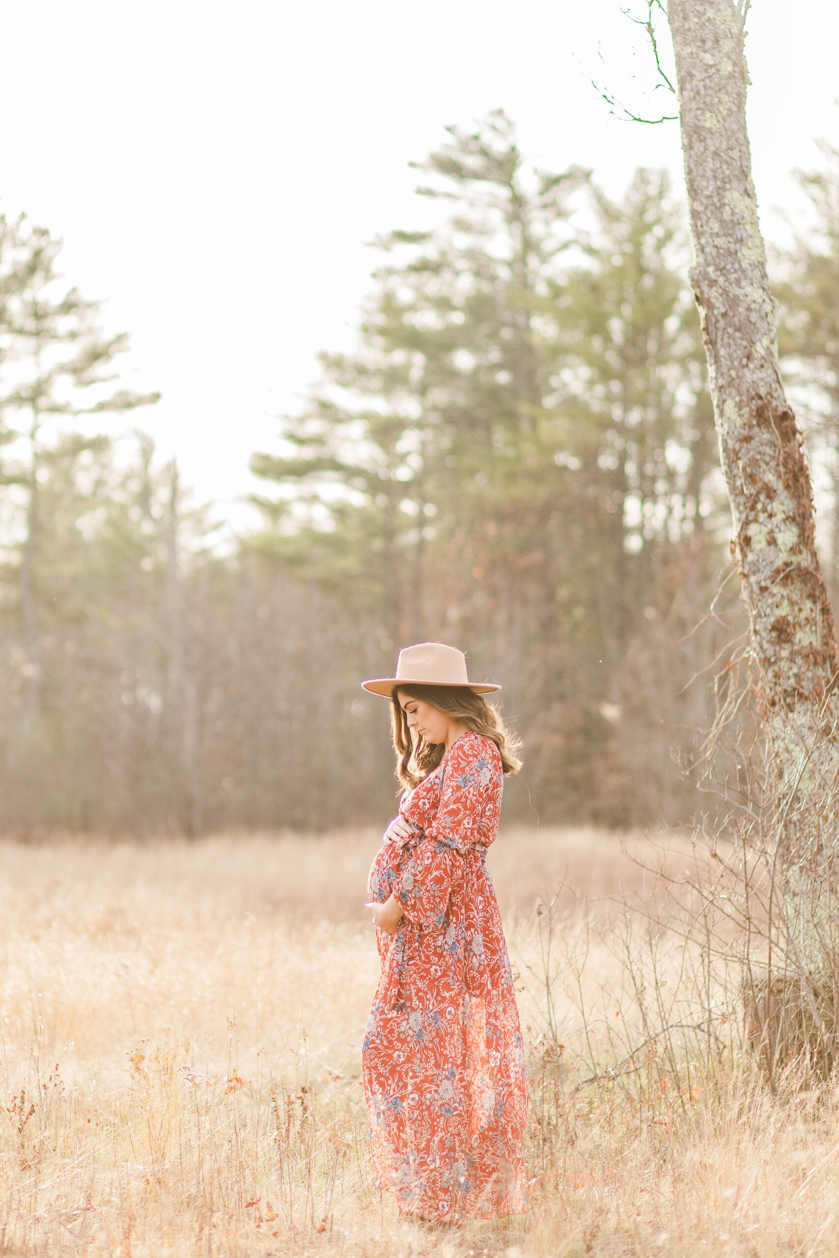 Pregnant woman in a hat standing in a field