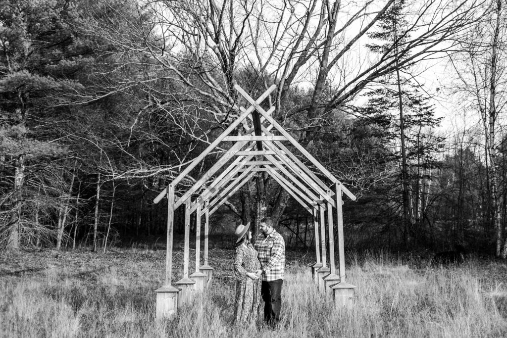 Couple standing under arch in field
