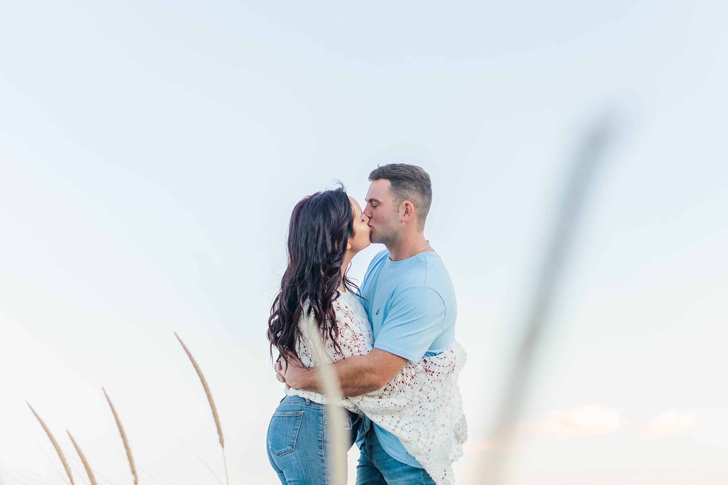 Man and woman kissing in dunes at Plum Island