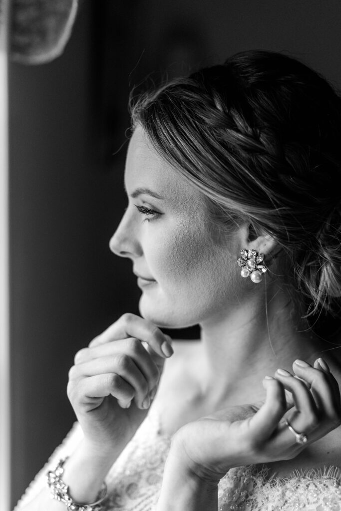 Black and white photo of bride touching her earring