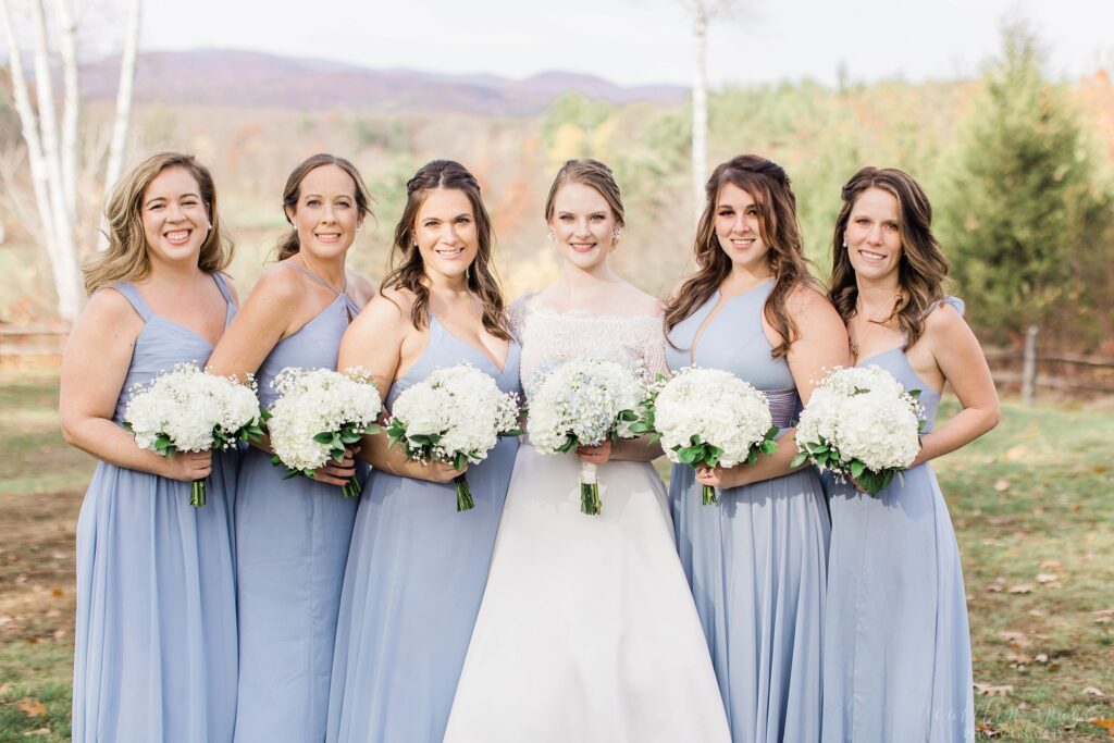 Bridesmaids in blue standing together at Barn on the Pemi