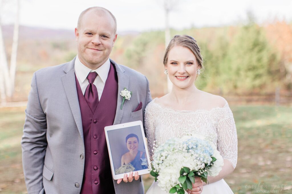 Bride and groom holding iPad with bridesmaid on it