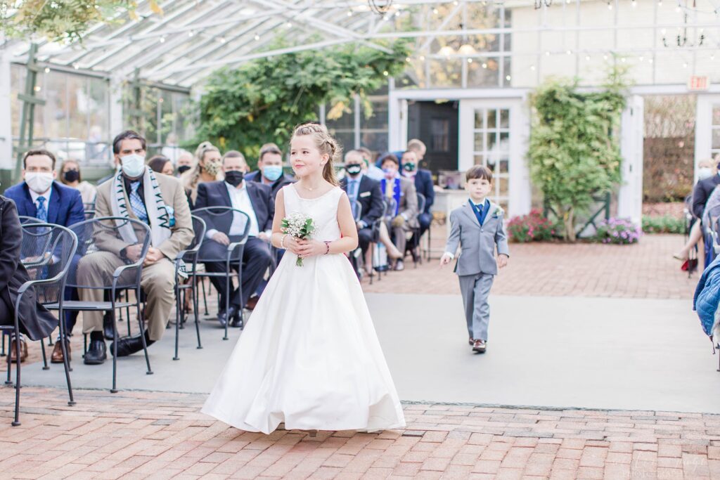 Flower girl and ring bearer walking down the aisle together