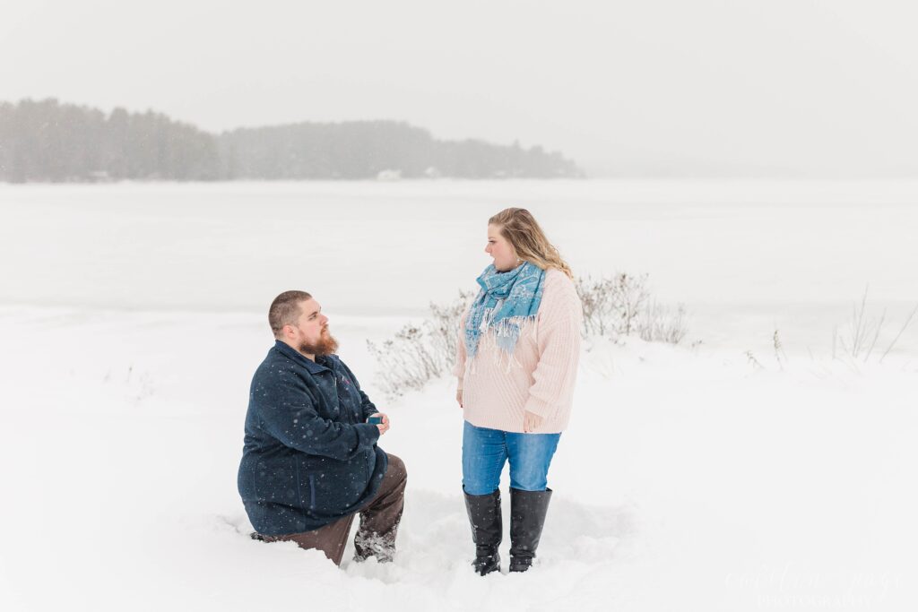 Man proposing on one knee in the snow winter proposal