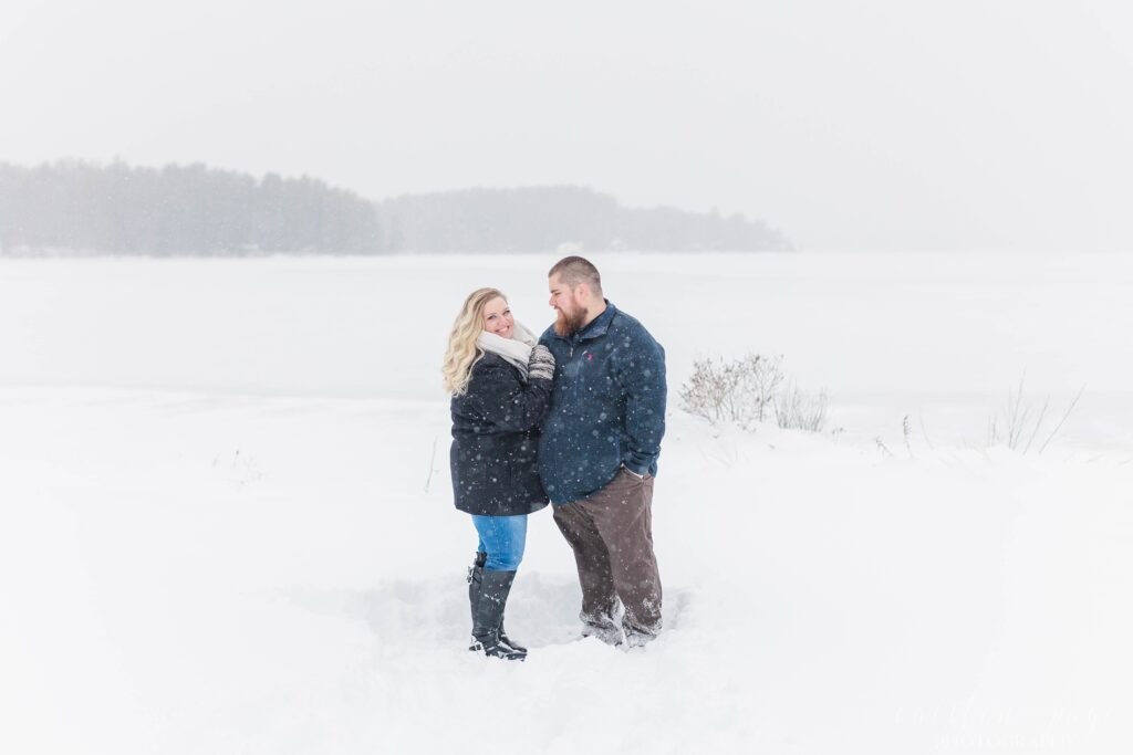Man and woman standing together in the snow at winter proposal