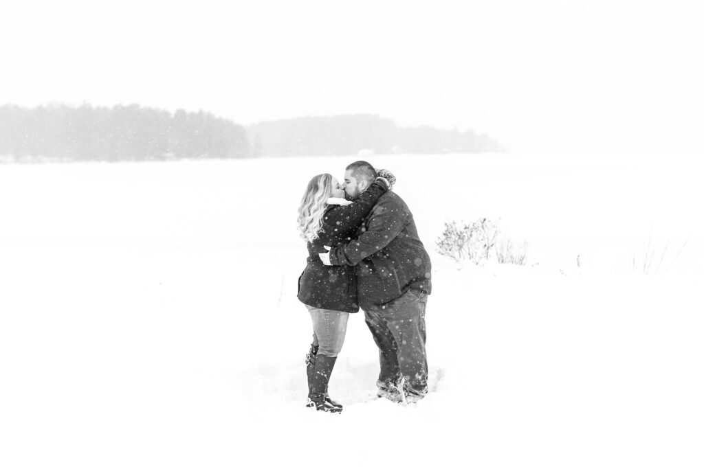 Man and woman standing together in the snow at winter proposal