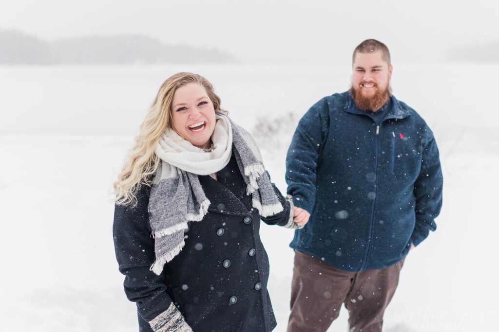 Man and woman standing in the snow together at winter proposal