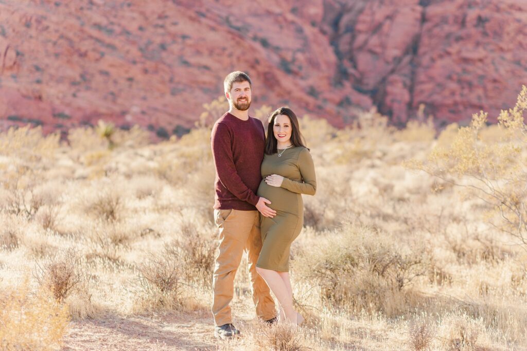 Man and pregnant woman standing together in desert
