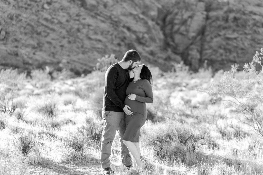 Black and white photo of man and pregnant woman in the desert