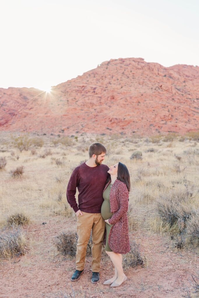 Pregnant woman and husband standing in desert together