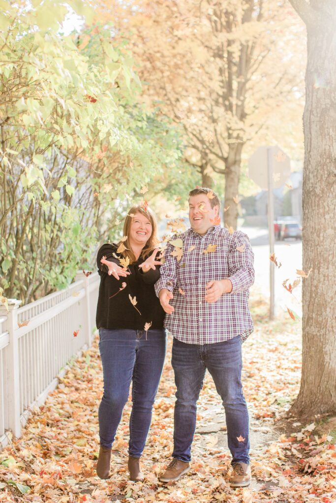Couple throwing fall leaves in the air