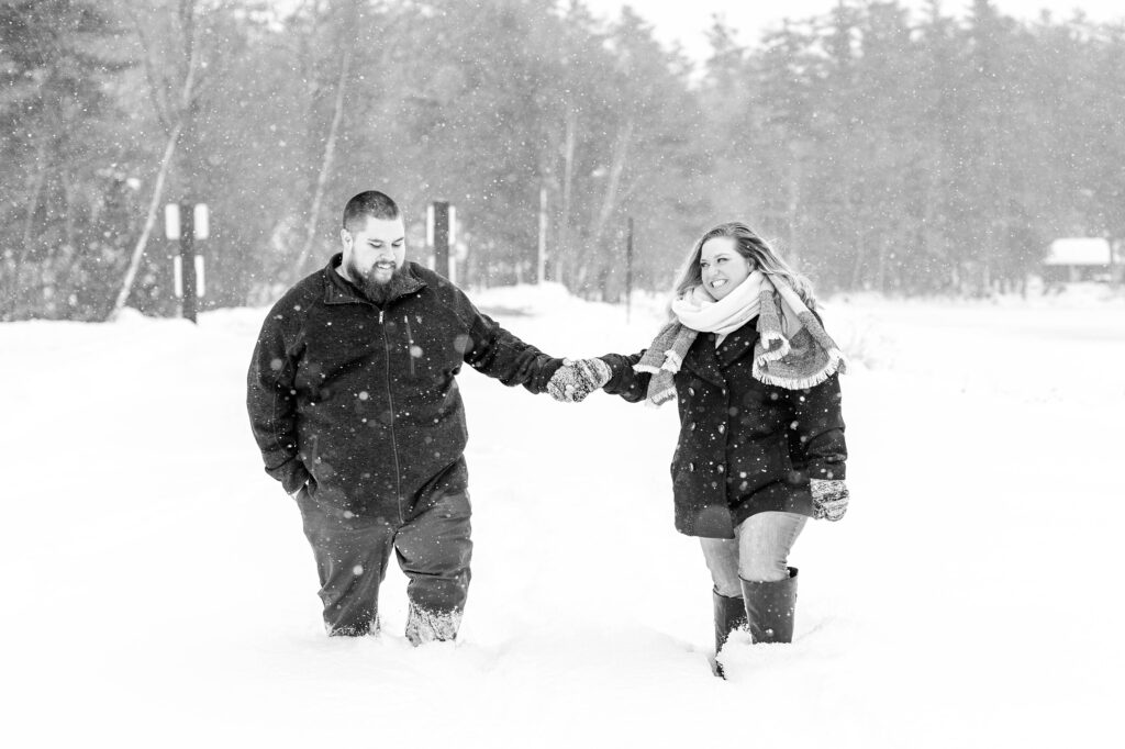 Black and white photo of couple walking in the snow