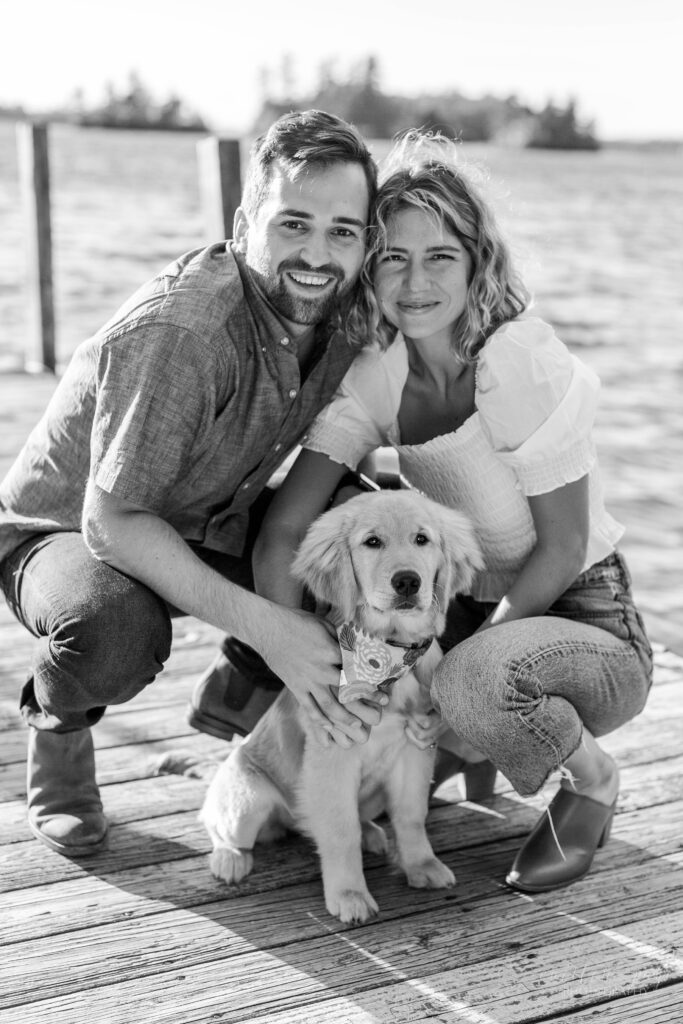 Couple on a dock with golden retriever puppy