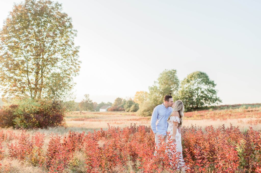 Couple standing in middle of red leaves