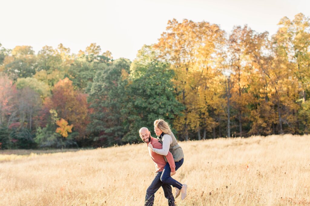 Man carrying woman on his back in a field