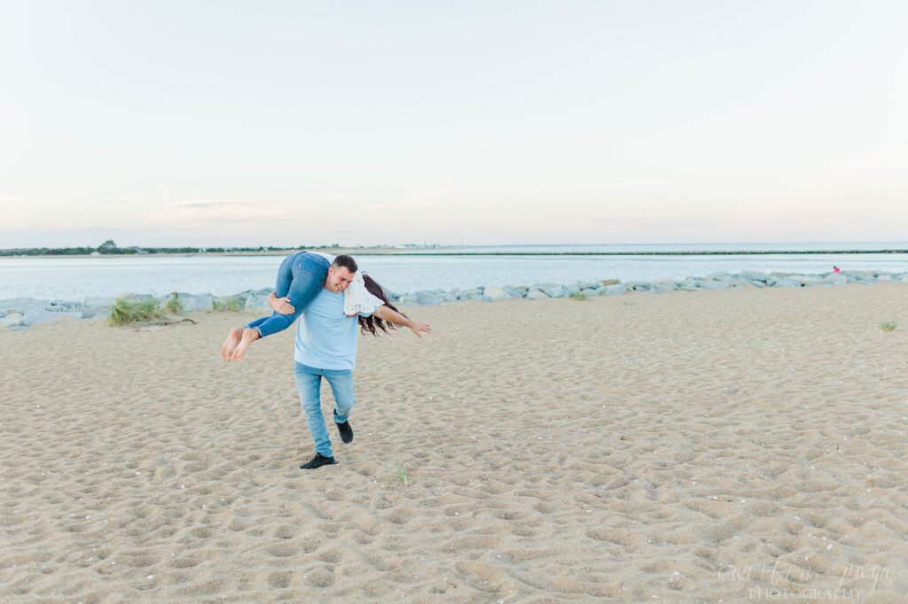 Man twirling woman around on the beach