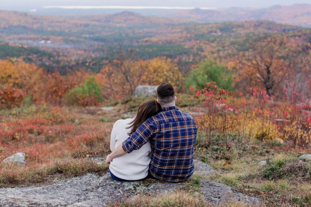 Man and woman sitting together on top of mountain