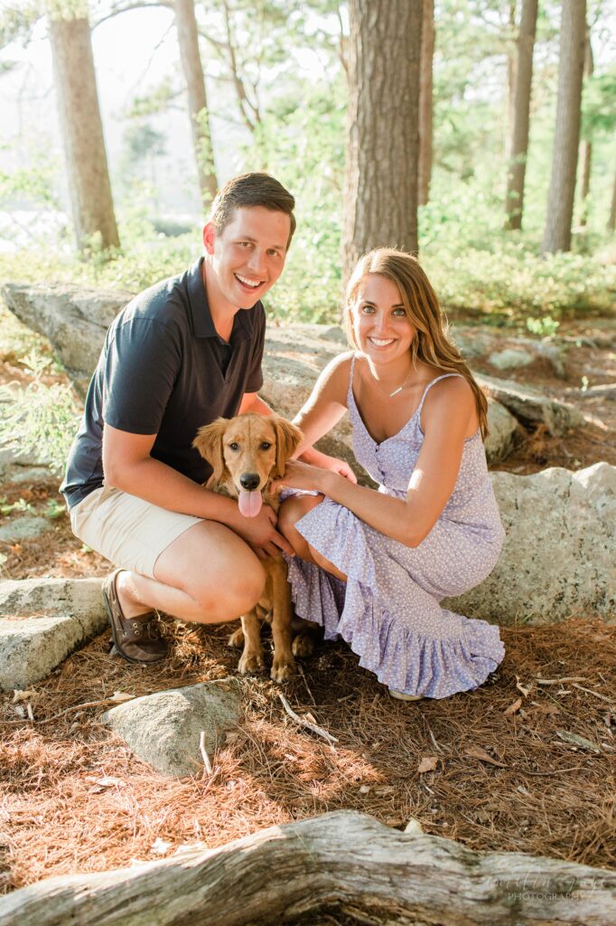 Couple sitting with golden retriever at engagement session
