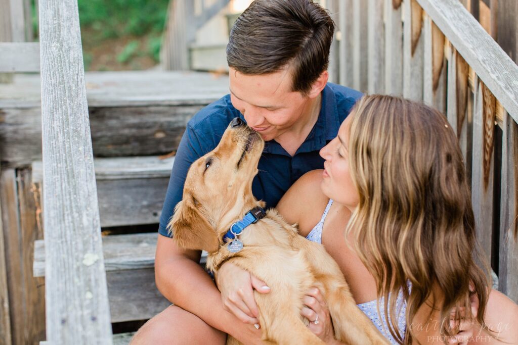 Couple sitting on steps with golden retriever puppy