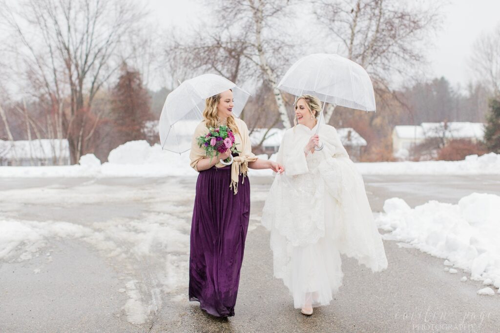 Bride and bridesmaid walking through snowy parking lot